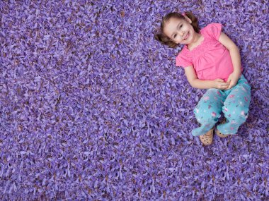 Girl lying on purple flowers clipart