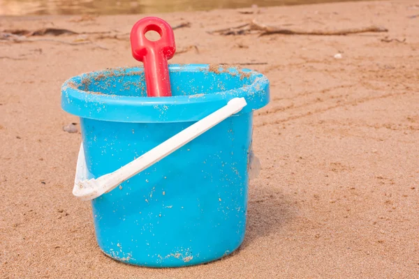 Crianças balde de praia azul com pá vermelha — Fotografia de Stock