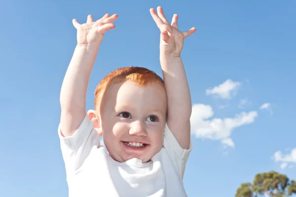 Söta unge med händerna i luften — Stockfoto