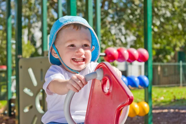 Ragazzo sorridente sul parco giochi per bambini — Foto Stock
