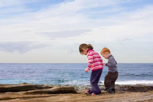 Děti se hrabat v beach rockpools — Stock fotografie