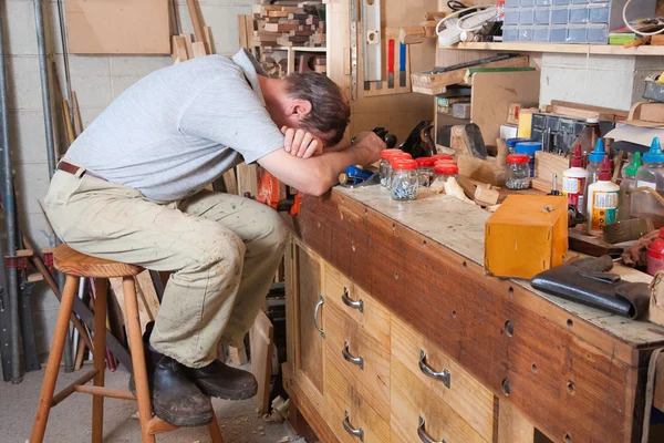 Head on arms on workbench — Stock Photo, Image