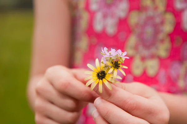 Chica joven sosteniendo flores de primer plano —  Fotos de Stock