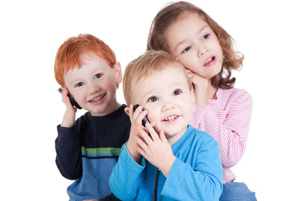 Cep telefonlarında konuşma üç mutlu çocuk — Stok fotoğraf