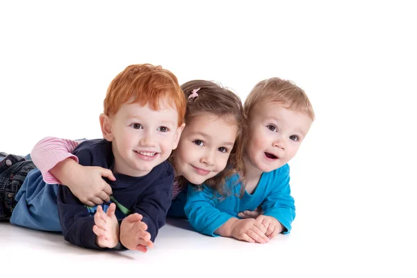Tre glada barn på golvet tillsammans — Stockfoto