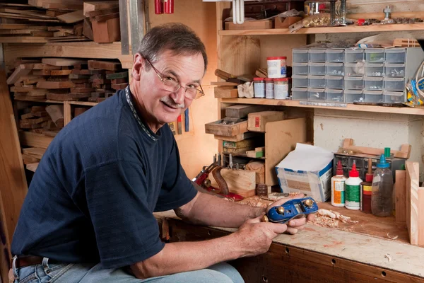 Homme assis à l'établi dans l'atelier — Photo