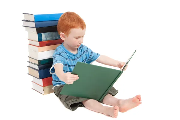 Menino encostado a livros e leitura — Fotografia de Stock