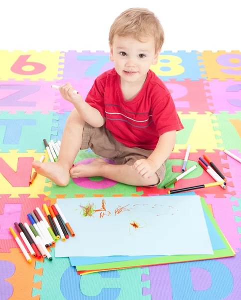 Junge Kind zeichnet auf Kindermatte — Stockfoto