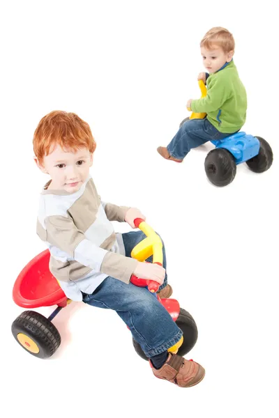 Мальчики катаются на детских трехколесных велосипедах — стоковое фото