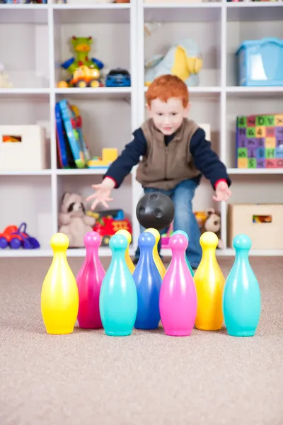 Leende pojke leker barnen bowlingspel — Stockfoto