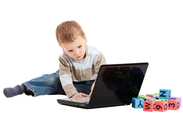 Junge lernt Lesen mit Kinderblöcken und Computer — Stockfoto