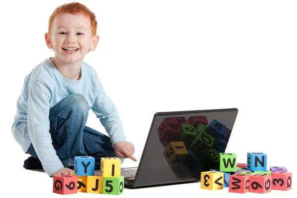 Niño en la escuela con computadora y bloques de niños — Foto de Stock