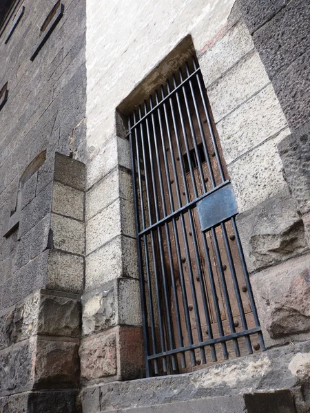 Old stone jail wooden door with iron bars — Stock Photo, Image