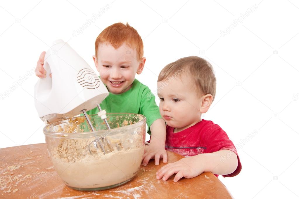 Boys baking cookies with electric mixer