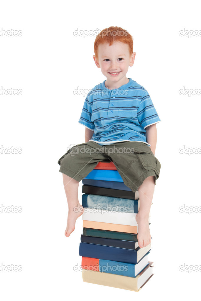 Boy sitting on stack of books