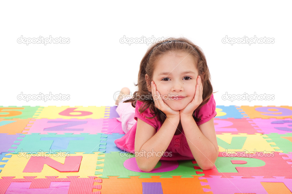 Girl lying on alphabet mat