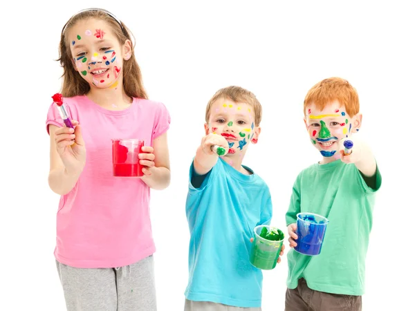 Happy messy kids with paint brushes — Stock Photo, Image