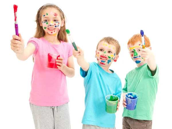 Smiling messy kids with paint brushes — Stock Photo, Image