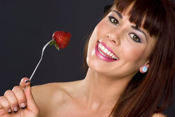 Happy ganska brunett kvinna håller gaffel mat frukt jordgubb — Stockfoto