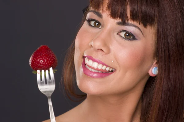 Hermosa morena sosteniendo tenedor comida fruta fresa — Foto de Stock