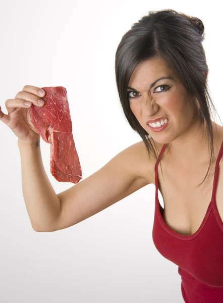 Schöne Brünette hält rohes rotes Steakfleisch in der Hand — Stockfoto