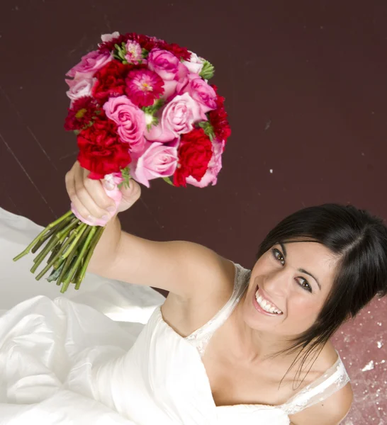 Braut sitzend mit Blumenstrauß — Stockfoto