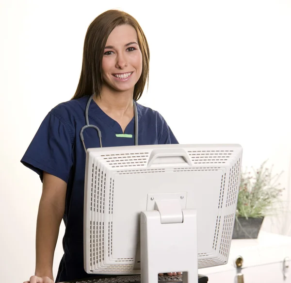 Arbeitende Krankenschwester speichert Daten am Computerarbeitsplatz — Stockfoto