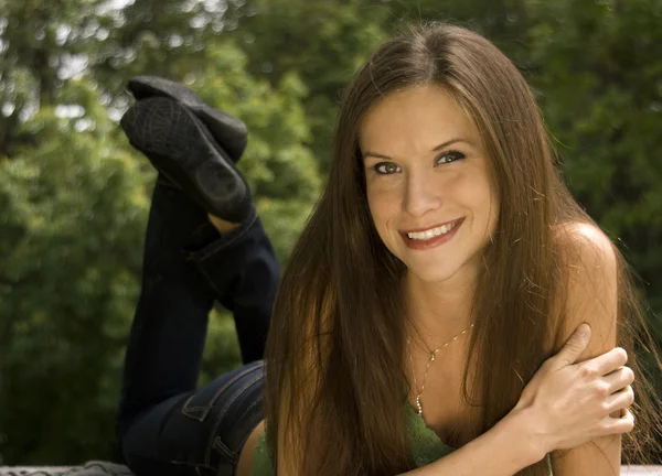 Belle femme dans le parc posée sur la table de pique-nique — Photo