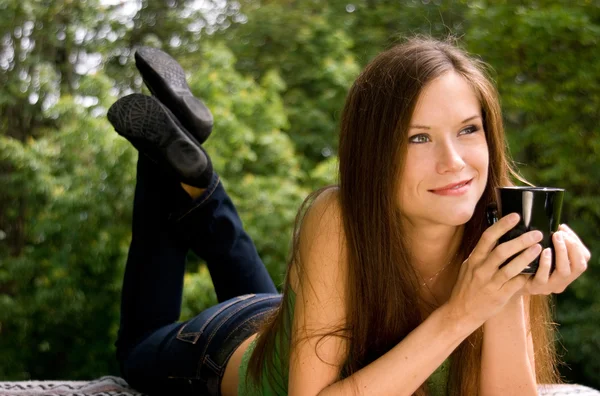 Vrouw weerspiegelt denken genot van een koffiekopje in het park — Stockfoto