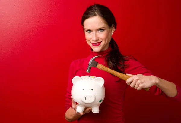 Vrouw neemt hamer raken piggy bank probeert om geld te krijgen — Stockfoto