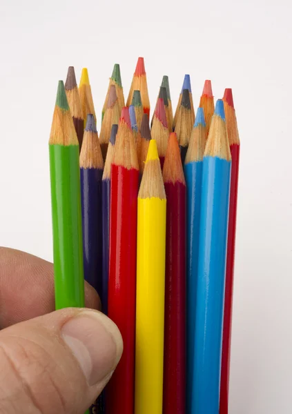Dedos tocam um lápis de cor verde de um grupo — Fotografia de Stock