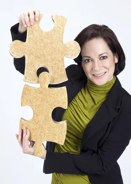 Donna che lavora con due pezzi puzzle di grandi dimensioni — Foto Stock