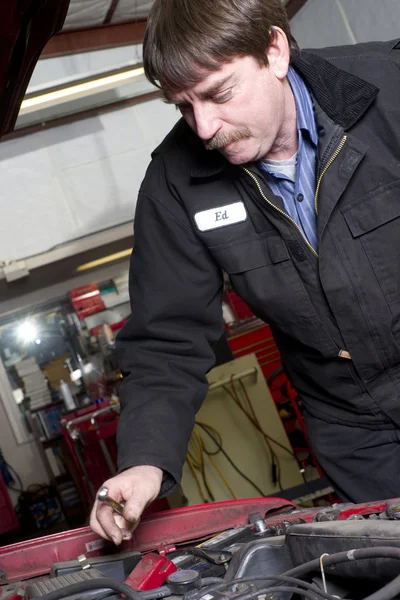 Kfz-Techniker arbeitet unter der Haube in der Autoreparatur — Stockfoto