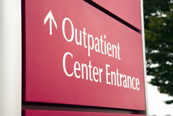 Μεγάλο κόκκινο νοσοκομείο εξωτερικών ασθενών κέντρο έκτακτης ανάγκης είσοδο υγείας αυτοκινήτων — Φωτογραφία Αρχείου