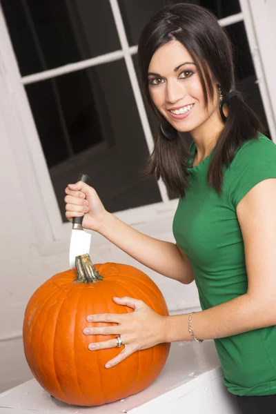 Woman preps Pumpkin for Halloween