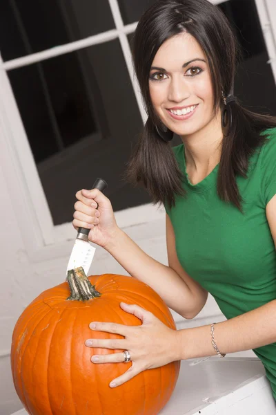 Opgewonden vrouw snijden snijwerk Halloween pompoen Jack-O-Lantern — Stockfoto