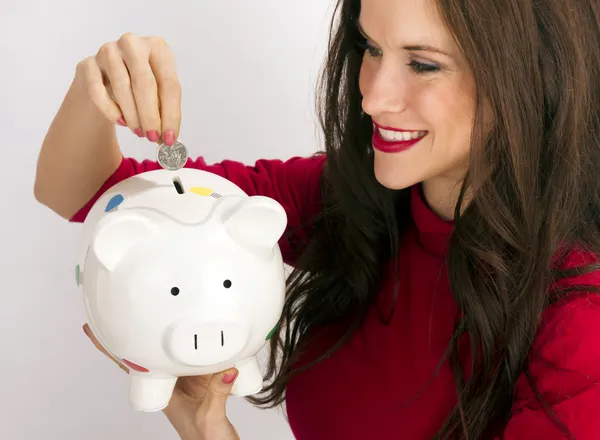 Vrij gelukkig brunette vrouw druppels kwartaal munt spaarbank — Stockfoto