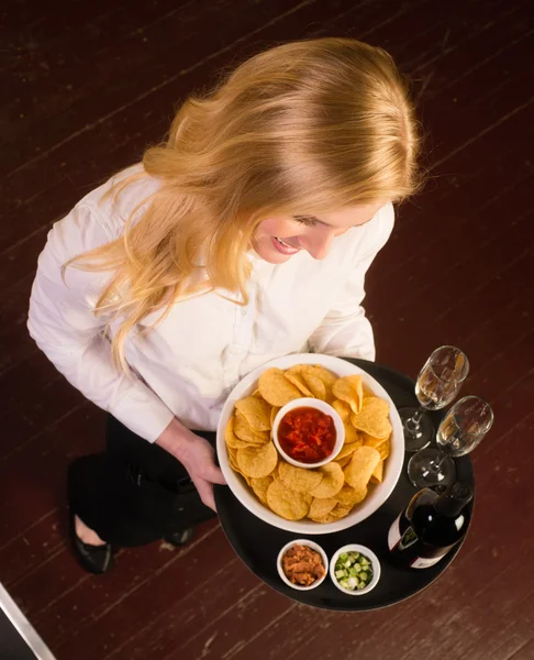 Fiatal, vonzó nő kiszolgáló hozza tálca chipek salsa bab előétel — Stock Fotó