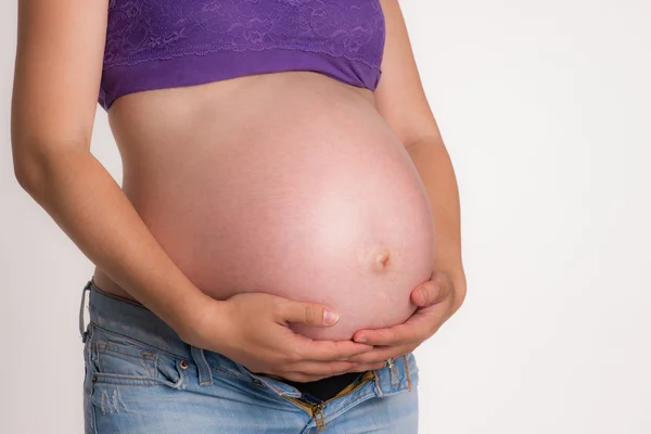 Donna incinta in attesa del busto del bambino mani in piedi sulla pancia — Foto Stock