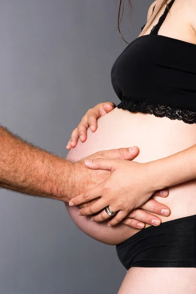 Adam kadının ortak bebek bekliyor hem de eller hamile mide touch — Stok fotoğraf