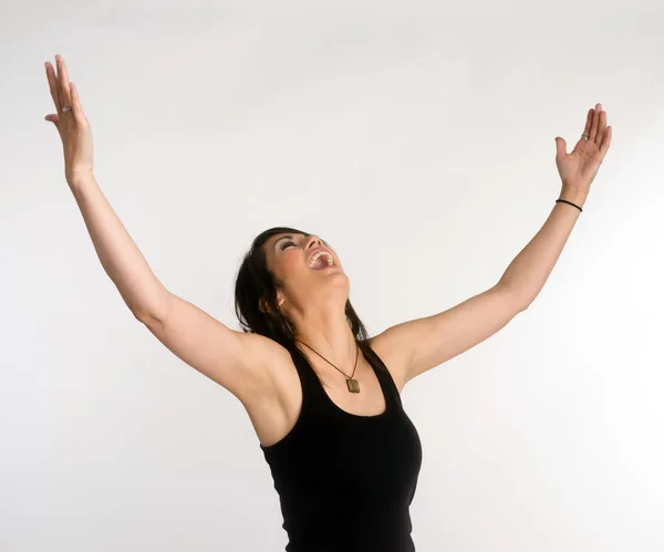 Bonita morena mujer sostiene los brazos extendidos jubiloso mirando hacia arriba —  Fotos de Stock
