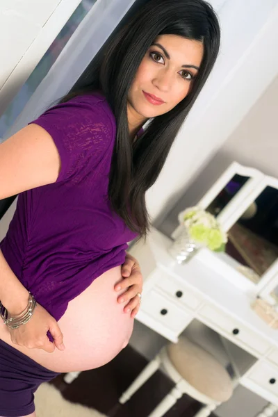 Vacker mycket gravid kvinna visar magen i sovrum spegel — Stockfoto