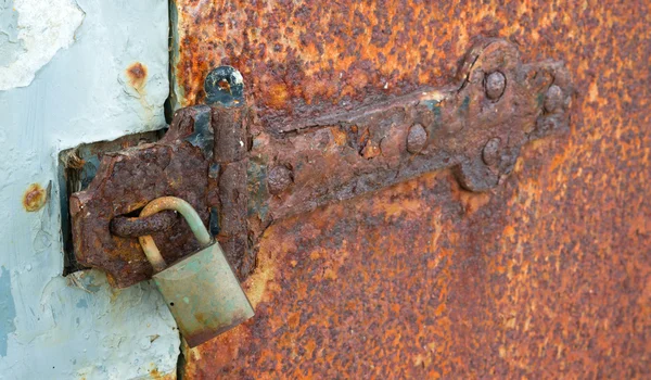 Visací zámek závěsu zrezivělý zamčené pevné kovové dveře — Stock fotografie