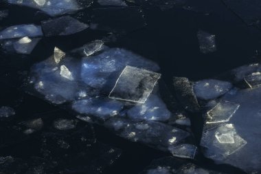 Karanlık sularda farklı şekillerde çok güzel kış buzları.