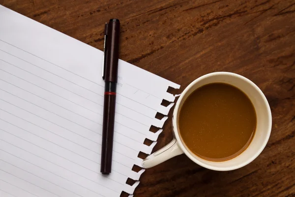 Кофе с запиской и ручкой на деревянном фоне — стоковое фото