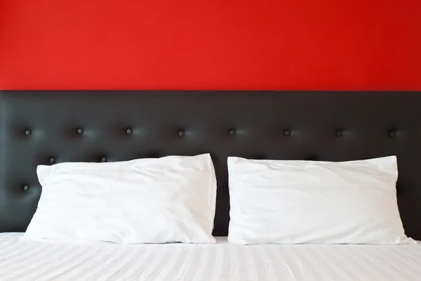 Beyaz yastıklar ve kırmızı yatak odasında yatağın üzerinde. — Stok fotoğraf