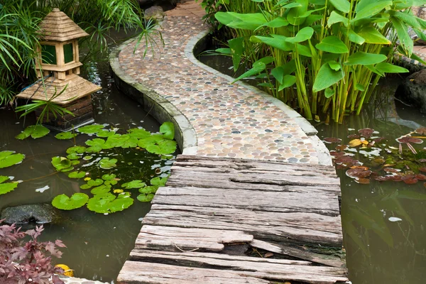 Sten och trä gångväg på vatten i parken — Stockfoto