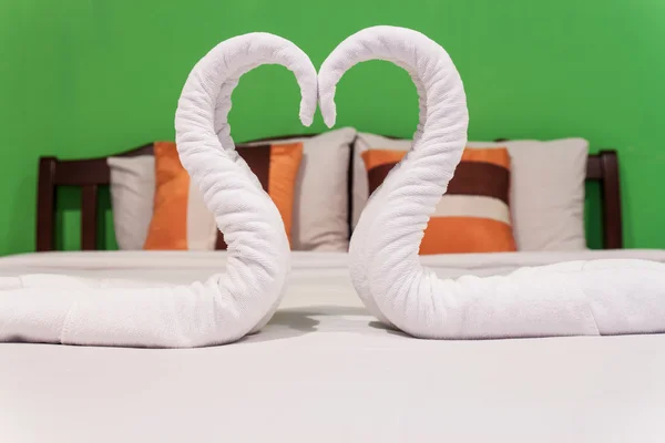 Havlu kuğuların beyaz yatakta — Stok fotoğraf