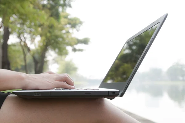 Woman in the park sitting on the grass with a laptop — Stock Photo, Image
