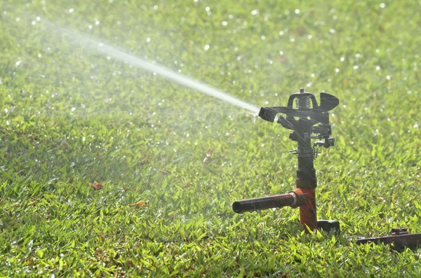 Irrigatore su erba verde — Foto Stock